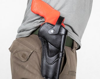 Könnte beinhalten: Ein schwarzes Lederholster mit einer roten und orangen Pistole darin. Das Holster wird an einem Gürtel getragen.