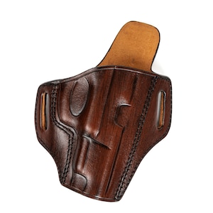 May include: A brown leather holster with a stitched design and a suede lining.