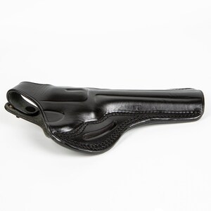 Pu&ograve; includere: Fondina in pelle nera con un design cucito e un passante per la cintura.