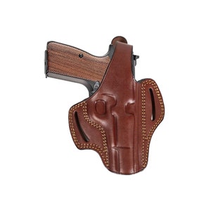 May include: A brown leather holster with a stitched design and a gun inside.