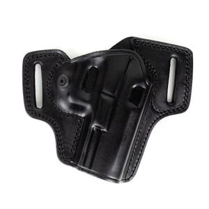 Op de afbeelding: Een zwart leren holster met een gevormd ontwerp voor een vuurwapen. De holster heeft gestikte randen en riemlussen voor bevestiging. Het leer heeft een glanzende afwerking en het ontwerp is functioneel en duurzaam.