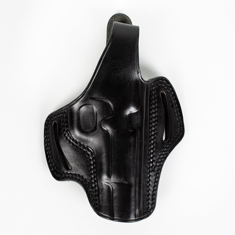May include: Black leather holster for a handgun. The holster has a belt loop and a thumb break.