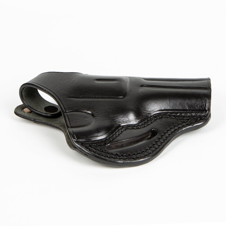 May include: A black leather holster for a handgun. The holster has a belt loop and a snap closure.