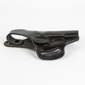 May include: A black leather holster for a handgun. The holster has a belt loop and a snap closure.