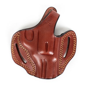 May include: A brown leather holster with a stitched design and a belt loop.