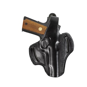 May include: A black leather holster for a handgun. The holster has a stitched design and a belt loop.