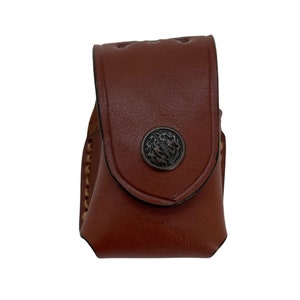 May include: A brown leather pouch with a decorative metal button. The pouch has a flap that closes with a snap.