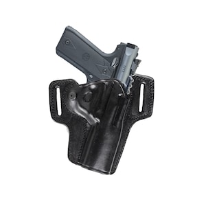 Op de afbeelding: Een zwart leren holster met een pistool erin. Het holster heeft een riemlus en een drukknopsluiting. Het pistool is een zilveren en zwart semi-automatisch pistool.