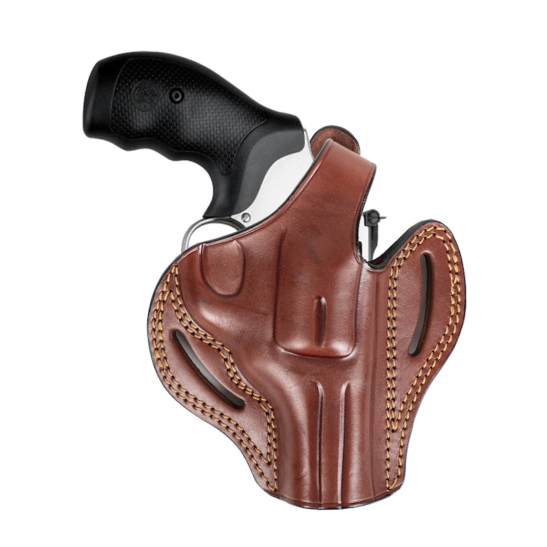 May include: A brown leather holster with a stitched design and a silver revolver inside.