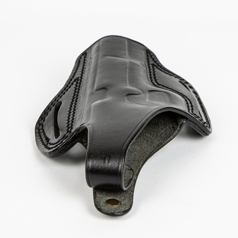 May include: A black leather holster with a stitched design and a belt loop.