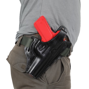 May include: A black leather holster with a red plastic gun inside. The holster is worn on a person's belt.