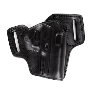 May include: A black leather holster with a molded design for a firearm. The holster features reinforced stitching around the edges and belt loops for secure attachment. The overall design is sturdy and functional.