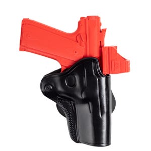 May include: A bright red handgun is partially inserted into a black leather holster. The holster has a molded design and a stitched pattern along the edge. The background is plain white.