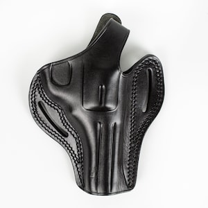 Könnte beinhalten: Ein schwarzes Lederholster für eine Pistole. Das Holster hat eine Gürtelschlaufe und einen Daumenverschluss.