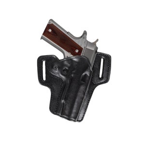 Könnte beinhalten: Ein schwarzes Lederholster für eine Pistole. Das Holster hat eine Gürtelschlaufe und einen Druckknopfverschluss. Die Pistole ist nicht im Lieferumfang enthalten.