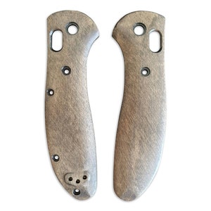 May include: A pair of brown wood knife scales with black accents. The scales are designed to fit a pocket knife.