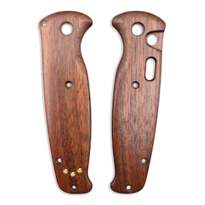 Peut inclure: Deux plaquettes de manche de couteau en bois brun foncé. Les plaquettes présentent un grain de bois visible. Chaque plaquette comporte plusieurs trous et une forme incurvée pour une prise en main confortable. De petits rivets en laiton sont visibles.