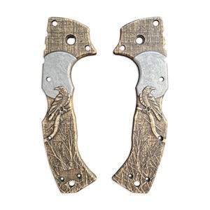 Könnte beinhalten: Ein Paar braune Holzgriffschalen mit einem silbernen Metalleinsatz und einem geschnitzten Rabendesign.