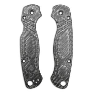 May include: Two gray carbon fiber knife handle scales. Each scale has a textured pattern, multiple holes, and a curved shape with a grip. The scales are designed to be attached to a knife.