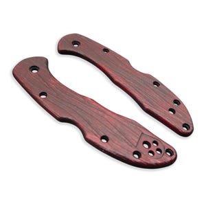 Puede incluir: Dos cachas de cuchillo rojo-marr&oacute;n con un patr&oacute;n de vetas de madera. Cada cacha tiene m&uacute;ltiples agujeros para la fijaci&oacute;n. Las cachas est&aacute;n dise&ntilde;adas para un cuchillo plegable y est&aacute;n hechas de un material duradero.