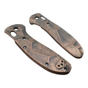 May include: Two brown, textured, knife scales with a geometric pattern. The scales have a slightly worn look and are made of a durable material.