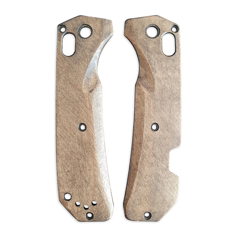 Op de afbeelding: Twee onafgewerkte houten mesbeslag met gaten voor het bevestigen van hardware. De beslag zijn lichtbruin van kleur en hebben een getextureerd oppervlak.