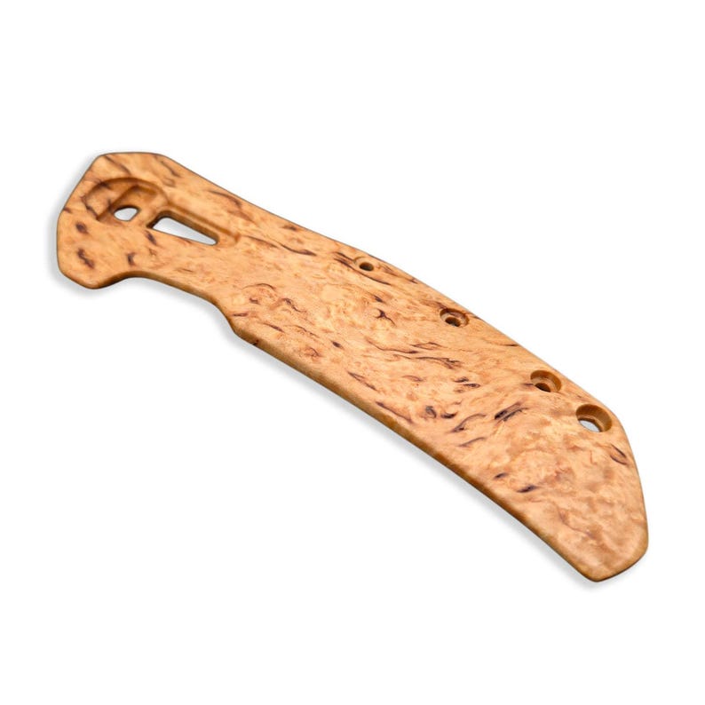 Puede incluir: Un mango de cuchillo de madera clara con un patr&oacute;n de vetas de madera natural. El mango tiene una forma curva con varios agujeros perforados y un recorte rectangular cerca de la parte superior. La madera tiene un color marr&oacute;n c&aacute;lido con vetas marrones m&aacute;s oscuras.