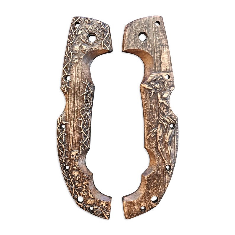 May include: Two wooden knife handle scales with intricate carvings. One scale features skulls and thorny vines, the other depicts a figure. Both are brown with drilled holes for attachment.