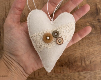 Natural ornament in Nordic style. Soft textile heart for Christmas tree. Primitive holiday decoration for rustic interior. Boho ecru bauble