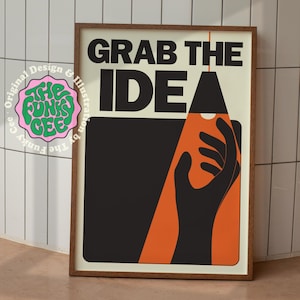 Op de afbeelding: Een ingelijste poster met de woorden "GRAB THE IDEA" in vette zwarte letters. De poster toont een zwarte hand die naar een lichtbron reikt, met een oranje driehoekvorm. De poster zit in een houten lijst.