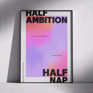 May include: A framed poster with the words "HALF AMBITION" and "HALF NAP" in bold black letters. The background features a gradient of colours, including orange, pink, and purple. The text "HUSTLE CULTURE SAID GO FASTER" and "MY BODY SAID GO NAP" are also visible.