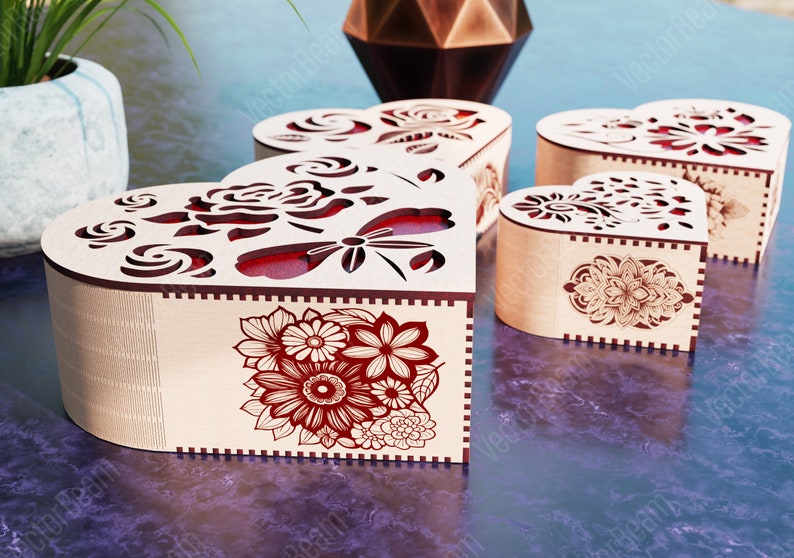 Pode incluir: Quatro caixas de madeira em forma de cora&ccedil;&atilde;o com desenhos florais intrincados e detalhes vermelhos. As caixas s&atilde;o feitas de madeira clara e t&ecirc;m um design delicado e intrincado.