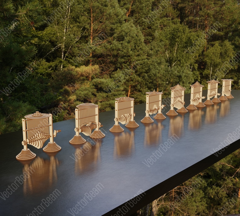 May include: A set of 10 wooden kinetic sculptures, each with a unique design and movement. The sculptures are arranged in a row on a wooden table, with a blurred background of green trees.
