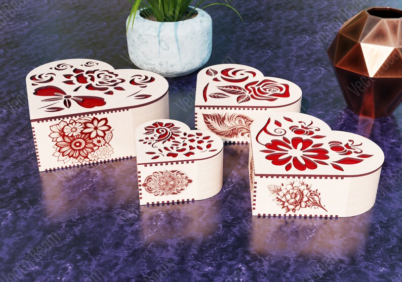 Pode incluir: Quatro caixas de madeira em forma de cora&ccedil;&atilde;o com intrincados desenhos florais vermelhos. As caixas s&atilde;o feitas de madeira clara e t&ecirc;m um toque delicado e rom&acirc;ntico.