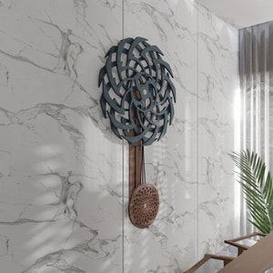 Puede incluir: Un reloj de pared de madera de color azul oscuro y marr&oacute;n con un dise&ntilde;o geom&eacute;trico. El reloj tiene un p&eacute;ndulo y una esfera circular con un patr&oacute;n geom&eacute;trico.