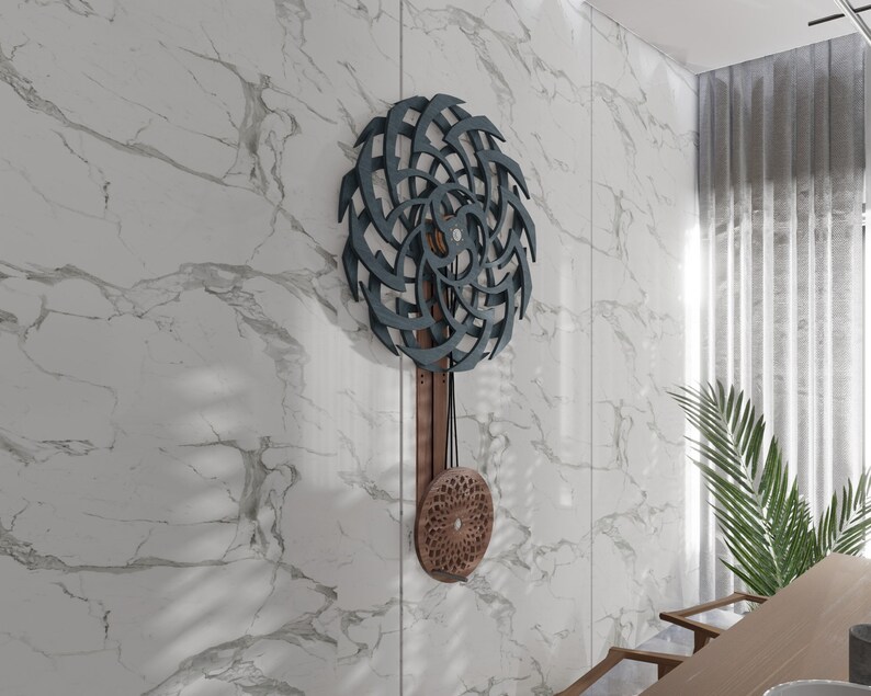 Puede incluir: Un reloj de pared de madera de color azul oscuro y marr&oacute;n con un dise&ntilde;o geom&eacute;trico. El reloj tiene un p&eacute;ndulo y una esfera circular con un patr&oacute;n geom&eacute;trico.