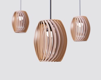 May include: Three wooden pendant lights with a slatted design hang from the ceiling. The lights are a light brown color and have a round shape.