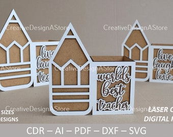 May include: Three white pencil-shaped boxes with brown interiors. The boxes have different text on the front: "Live Laugh Teach", "World's Best Teacher", and "Live Laugh Love".