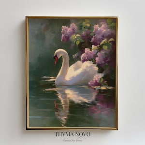Puede incluir: Una impresión artística enmarcada representa un cisne blanco deslizándose con gracia sobre el agua, con un fondo de flores moradas y exuberante vegetación. La obra de arte está enmarcada en un marco dorado, creando una estética serena y elegante. El texto "THYMA NOVO" y "Curated Art Prints" está en la parte inferior.