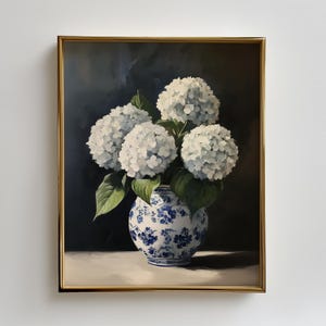 May include: A framed painting of white hydrangea flowers in a blue and white patterned vase. The artwork has a dark background and a gold frame, creating a classic and elegant aesthetic. The flowers are in full bloom.