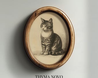 May include: An oval framed print featuring a detailed pencil sketch of a seated tabby cat. The cat has a striped coat and is set against a cream-colored background. The frame is made of wood. The text "THYMA NOVO Curated Art Prints" is at the bottom.