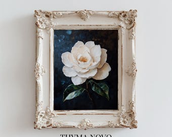 May include: A framed floral art print featuring a large white flower with green leaves against a dark background. The ornate, off-white frame has decorative detailing. The text "THYMA NOVO Curated Art Prints" is at the bottom.