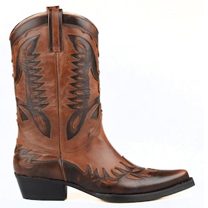May include: Brown leather cowboy boots with intricate stitching and a pointed toe.
