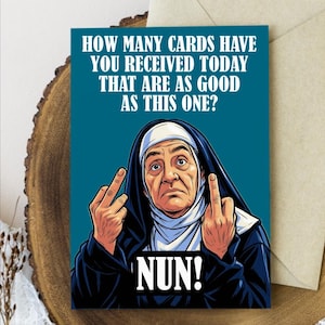May include: Greeting card with a teal background featuring a cartoon nun giving the middle finger. The card reads "HOW MANY CARDS HAVE YOU RECEIVED TODAY THAT ARE AS GOOD AS THIS ONE? NUN!" An envelope is behind the card.