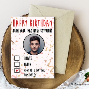 May include: A birthday card with the text "HAPPY BIRTHDAY FROM YOUR IMAGINARY BOYFRIEND." The card features a photo of a man, with check boxes for relationship statuses. The box next to "MENTALLY DATING TOM DALEY" is checked.
