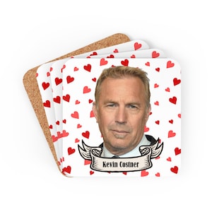 May include: A set of four coasters featuring a red heart pattern and a photo of Kevin Costner. The coasters have a cork backing and a white front with the text "Kevin Costner" in a banner.