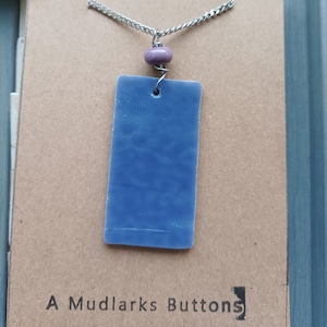 Handmade lilac stained glass pendant combined with a handmade lilac lampwork bead and stainless steel chain.