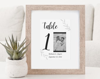 Puede incluir: Un cartel de número de mesa de boda enmarcado con una foto en blanco y negro de una pareja, el texto "Mesa 1" y la fecha "24 de septiembre de 2022".