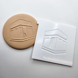 Può includere: Uno stampo in plastica marrone e bianco per realizzare biscotti o decorazioni di pasta di zucchero. Lo stampo presenta un design in rilievo della Kaaba, un edificio a forma di cubo a La Mecca, in Arabia Saudita, che è il luogo più sacro dell'Islam.