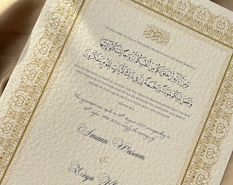 Può includere: Un certificato di matrimonio bianco con un bordo dorato ornato. Il certificato include un'iscrizione araba e il testo "This agreement was made on 18th August 2024 corresponding to 14th Safar 1446 AH to certify the marriage of Amaan Waseem & Xouya Khan".